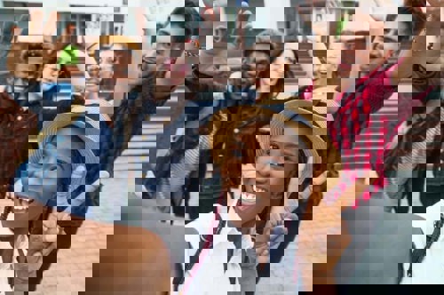 group of high school juniors taking a selfie in front of their school