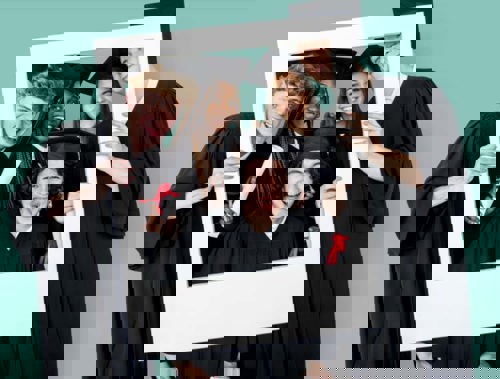 group of high school seniors in their caps and gowns holding a photo frame prop