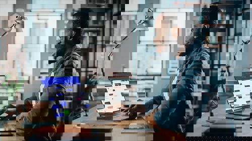 Male using laptop at home desk